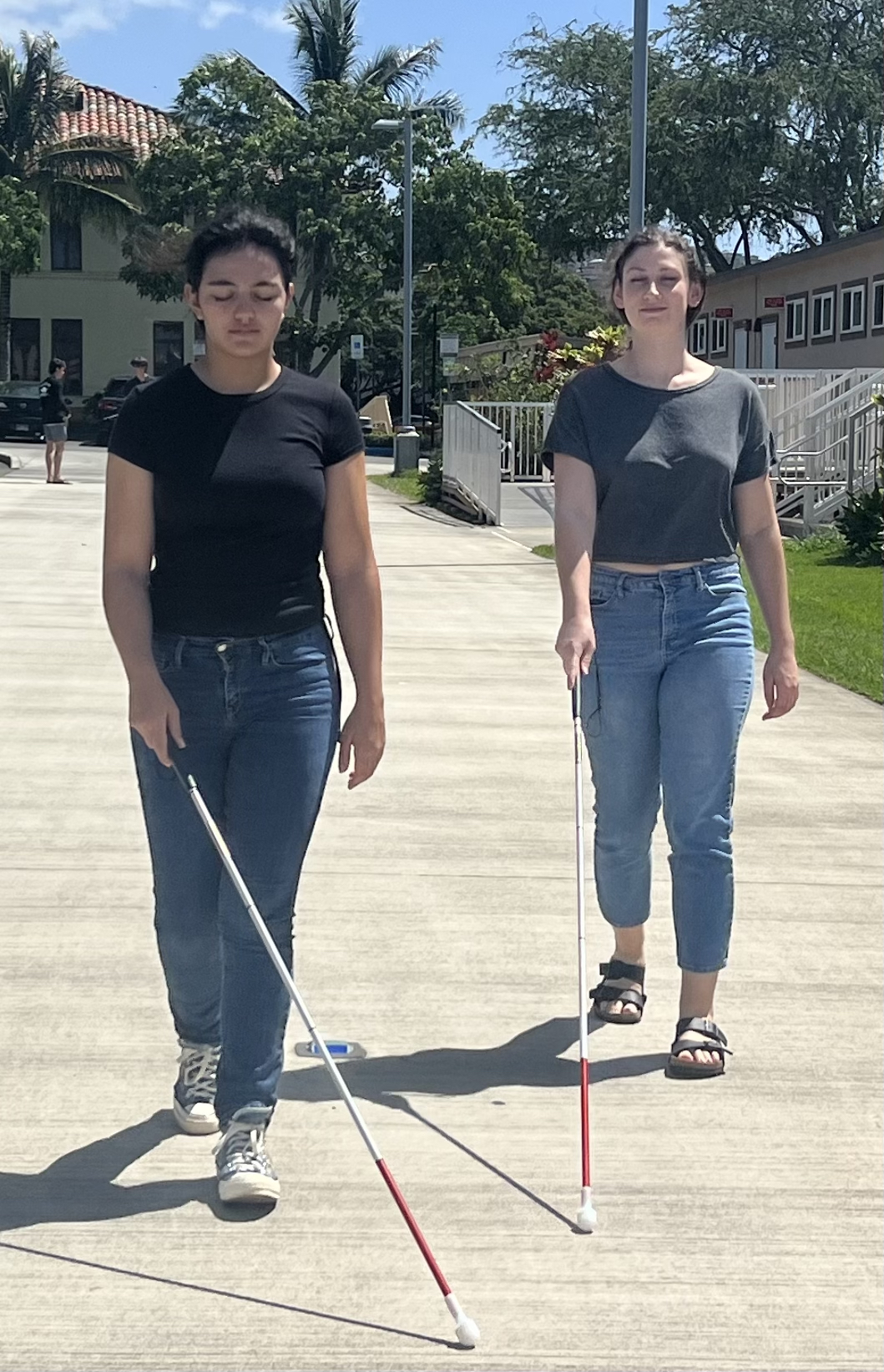 Two disability awareness participants practicing white cane techniques